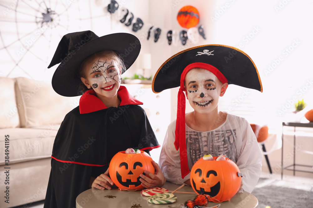 Sticker cute little kids with pumpkin candy buckets wearing halloween costumes at home