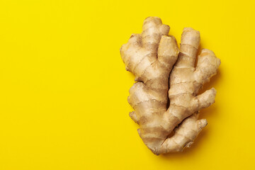 Fresh raw ginger on yellow background, space for text