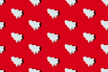 Red Christmas background. Fir tree seamless pattern. New Year party decorative composition. White clay figure minimalist arrangement isolated on bright.