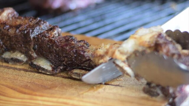primer plano de corte de asado de tira asado a la parrilla a las brasas sobre tabla de madera tipico y tradicional argentina