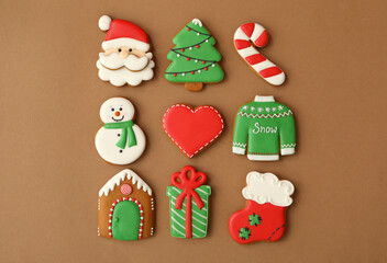 Different Christmas gingerbread cookies on brown background, flat lay