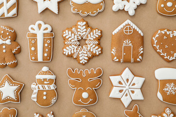 Different Christmas gingerbread cookies on brown background, flat lay
