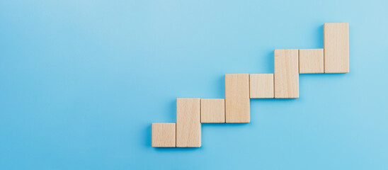 Wooden block stacking as step stair blue background, Ladder of success in business growth concept, copy space