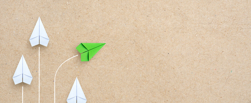 Group of white paper plane in one direction and one green paper plane pointing in different way. Business for innovative solution concept, copy space