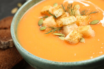 Delicious creamy pumpkin soup in bowl, closeup
