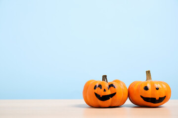 Pumpkins with scary faces on light blue background, space for text. Halloween decor