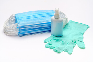 Disposable blue medical face mask, rubber latex gloves and alcohol hand sanitizer antiseptic on light grey background