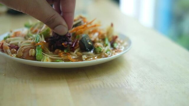 Somtum Thai spicy green papaya salad eat with black sticky rice by hand, eating in Thai style