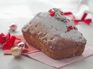 Christmas cake decorated with powder, rosemary and dried cranberries. Holiday treat. Selective focus on the front.