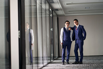 portrait of two asian businessmen standing in front of office