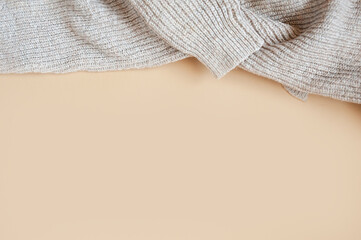 cozy large-knit wool sweater on a clean beige background, beige monochrome