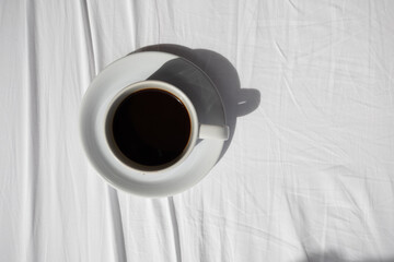 Top view Black coffee cup on a white cloth bed