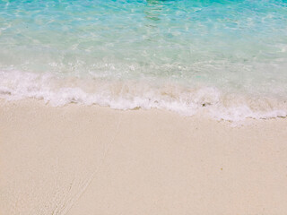 Fototapeta na wymiar Soft wave of blue ocean on sandy beach with copy space. Background, Wallpaper