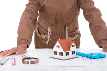 The architect lay on the table, meditating on the drawings and the house model