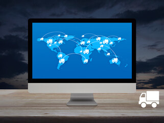 Delivery truck flat icon with connection line and world map on modern computer monitor screen on wooden table over sunset sky, Business transportation online concept, Elements of this image furnished 