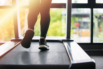 Fototapeta na wymiar Female muscular feet in sneakers running on the treadmill at the gym. Concept for fitness, exercising and healthy lifestyle.