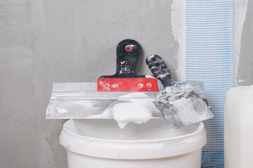 a bucket with a mixture and a tool for leveling the walls in the room © kurgu128