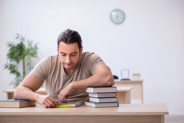 Young male student preparing for exams at library