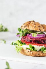 Vegan burger with beetroot cutlet and micro greens on white background.