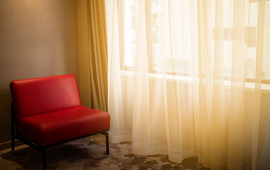 Vintage interior of living room, red sofa near window and white silk curtain with vintage carpet. Interior design concept