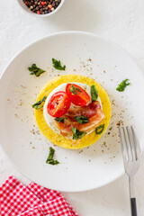 Polenta with mozzarella, bacon and tomatoes. Italian cuisine. Recipe.