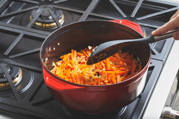 Frying chopped carrot and onion in cast dutch oven