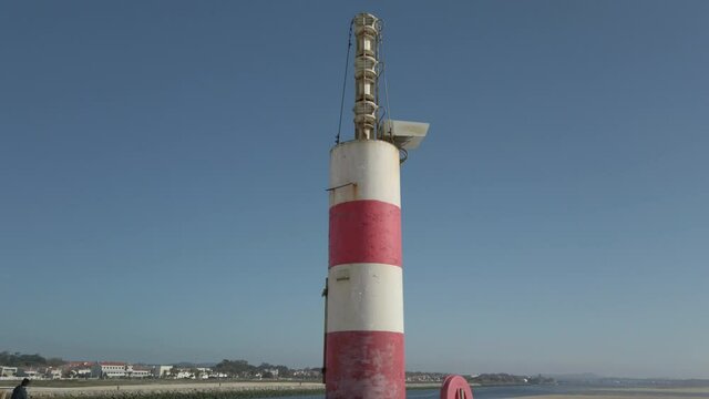 The two sides of Restinga de Ofir. The Ronca de Esposende, a red and white colored beacon alerts on the pier, Portugal.