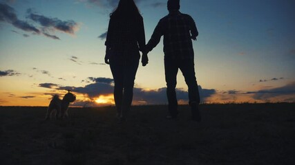 happy family couple and dog runs hands at sunset lifestyle on a hilltop. concept of team business concept travel freedom victory happiness teamwork. happy family parents hold hands run in the rays of