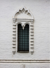 Obraz premium Old white stone window in the old Russian style. An old window of a 16th-century Church in Russia.