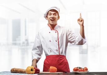 Young male chef standing near cooking table
