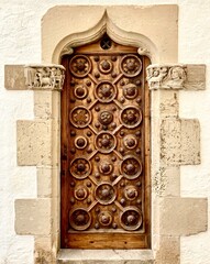 porte ancienne en bois avec décoration orientale posée sur un mur en pierre de taille