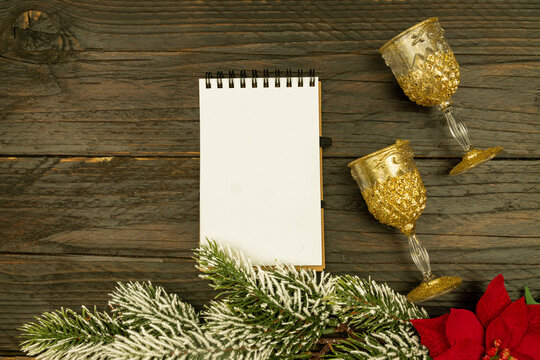 Happy New year 2021 celebration. Champagne glasses and blanck spyral notepad on wooden background. Flat lay.