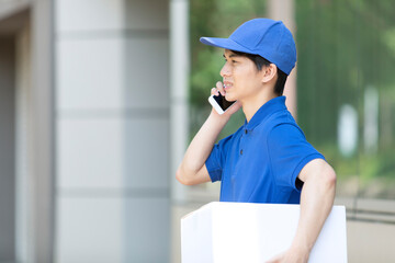 電話をする配達員の男性