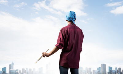 Young male artist holding paintbrush