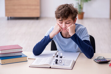 Schoolboy looking at molecular model at home