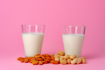Non-dairy vegan milk made of nuts in glassware against pink background