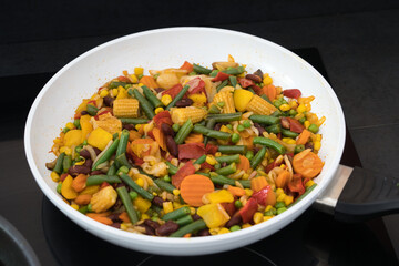 Vegane, vegetarische Gemüsepfanne mit Babymais, Bohnen, Kidneybohnen, Erbsen, Buttergemüse