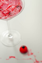 Halloween drink in a martini glass based on vodka, cream liqueur and grenadine with an edible decorative element in the shape of an eye