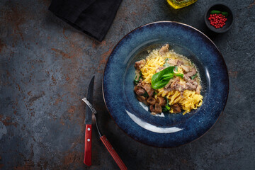 Creamy tagliatelle pasta with mushrooms, cheese and spinach on a plate