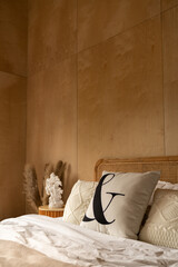 Stylish Bedroom corner with rattan headboard bed and soft pillow decoration with  with plywood wall on the background / cozy interior design / copy space