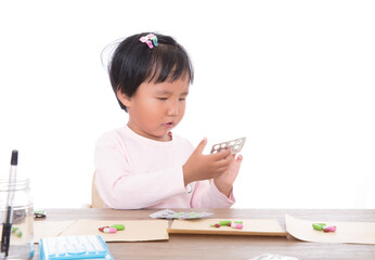 Yellow skin Chinese little girl pretending to be doctor dispensing medicine