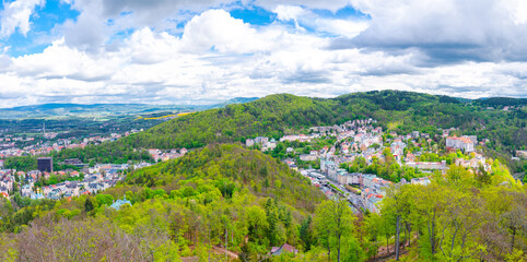 Fototapeta na wymiar Karlovy Vary city aerial panoramic view with row of colorful multicolored buildings and spa hotels in historical city centre. Panorama of Karlsbad town and Slavkov Forest hills, Czech Republic