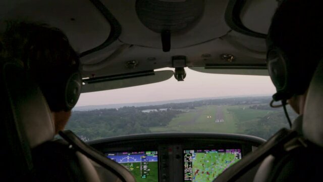 Pilot and pilot inside cockpit, prop plane flies over landscape