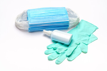 Disposable blue medical face mask, rubber latex gloves and alcohol hand sanitizer antiseptic on light grey background