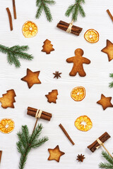 Christmas composition. Christmas gingerbread cookies, pine branches, and cinnamon sticks. New Year figure biscuits.