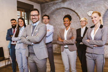 Portrait of confident business team standing in office with their hands crossed