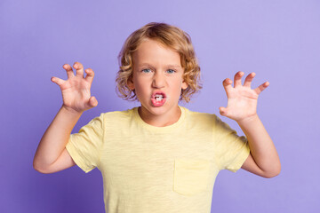 Photo of frightening small boy look in camera raise hands claws isolated over violet color...