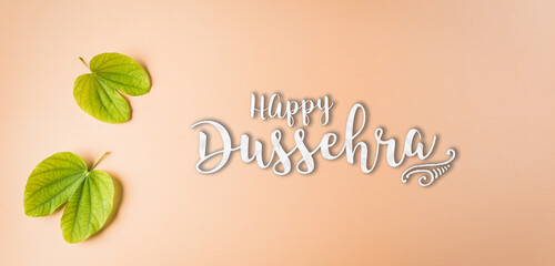 Happy Dussehra, Green leaf on orange pastel background. Dussehra Indian Festival concept.