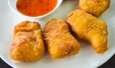 chicken nuggets with thai chicken sauce on white plate.
