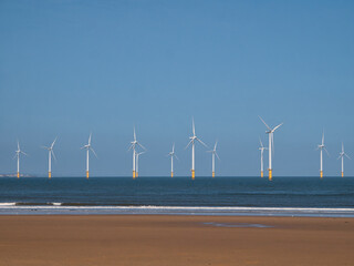 Wind turbines of the offshore Redcar / Teeside Wind Farm, located on the north east coast of England in the UK - taken on a sunny day with a blue sky at the end of summer.